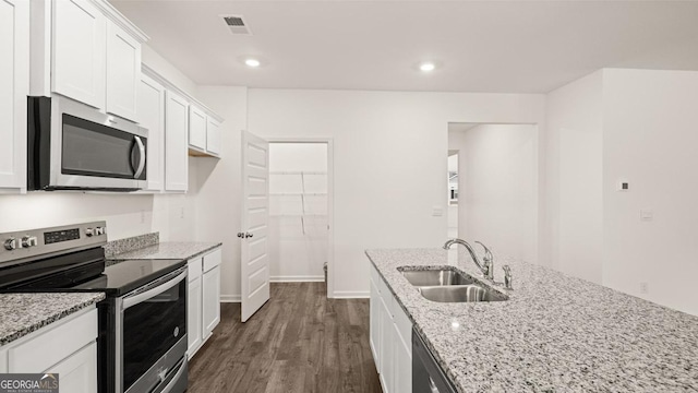 kitchen with white cabinets, dark wood finished floors, visible vents, a sink, and appliances with stainless steel finishes