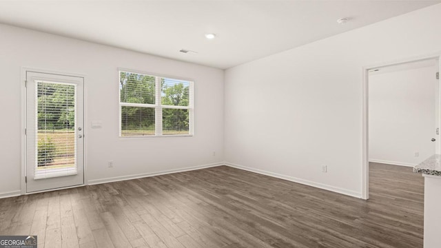 empty room featuring baseboards and dark wood-style flooring