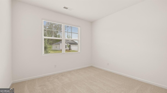 empty room with light carpet, visible vents, and baseboards