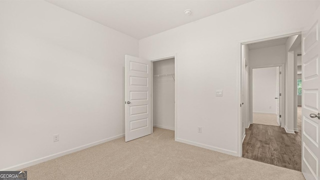 unfurnished bedroom with baseboards, carpet floors, and a closet