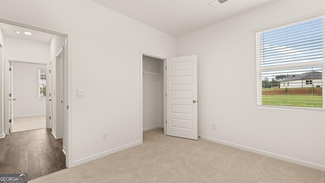 unfurnished bedroom with visible vents, baseboards, carpet flooring, and multiple windows