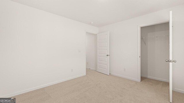 unfurnished bedroom featuring baseboards, carpet, and a closet