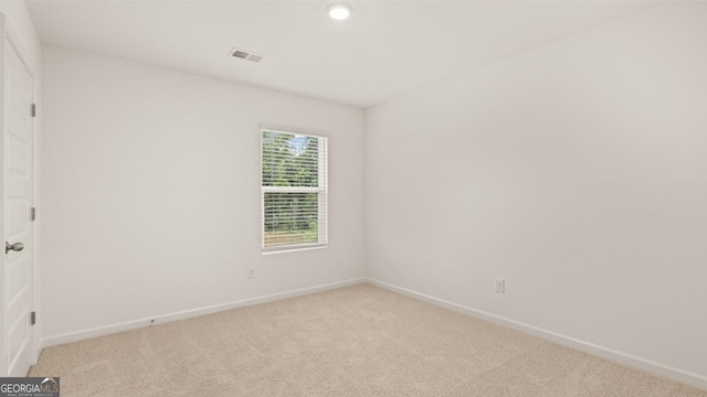 spare room featuring light colored carpet, baseboards, visible vents, and recessed lighting