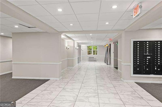 hallway featuring recessed lighting, a paneled ceiling, baseboards, and marble finish floor
