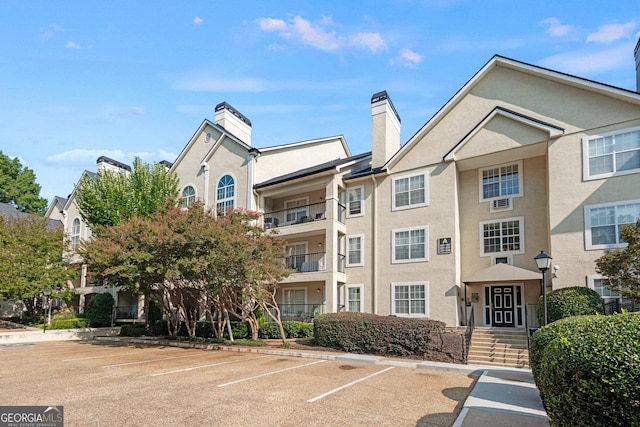 view of building exterior with uncovered parking