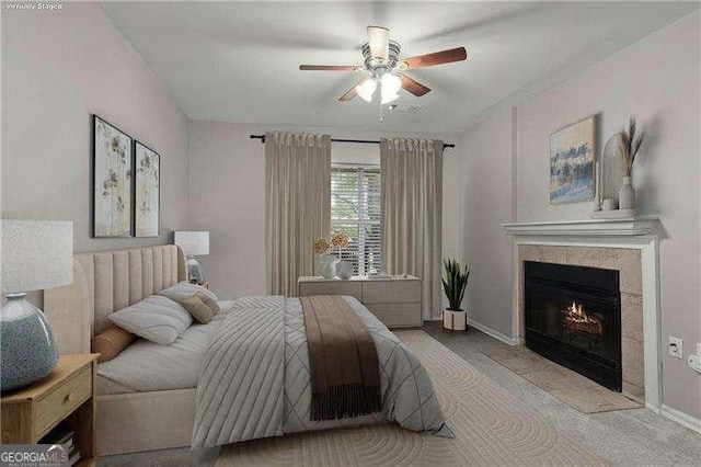 bedroom with baseboards, a ceiling fan, and a fireplace