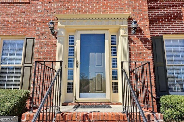 doorway to property featuring brick siding