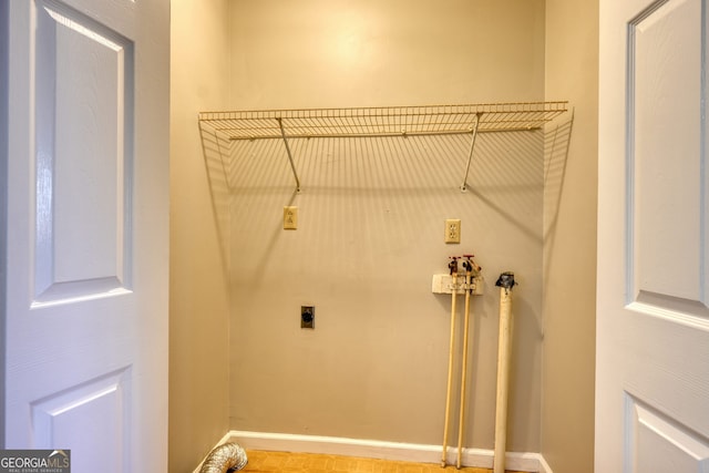 washroom with electric dryer hookup, baseboards, and laundry area