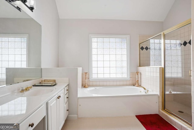 bathroom featuring vanity, lofted ceiling, a stall shower, a garden tub, and tile patterned flooring