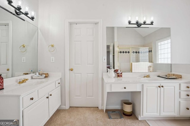 bathroom featuring a stall shower, lofted ceiling, a sink, and two vanities