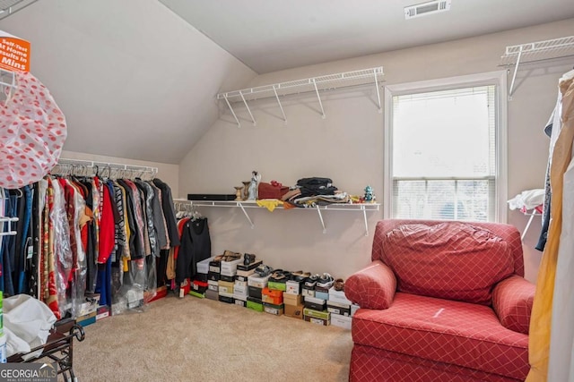 spacious closet with lofted ceiling, visible vents, and carpet