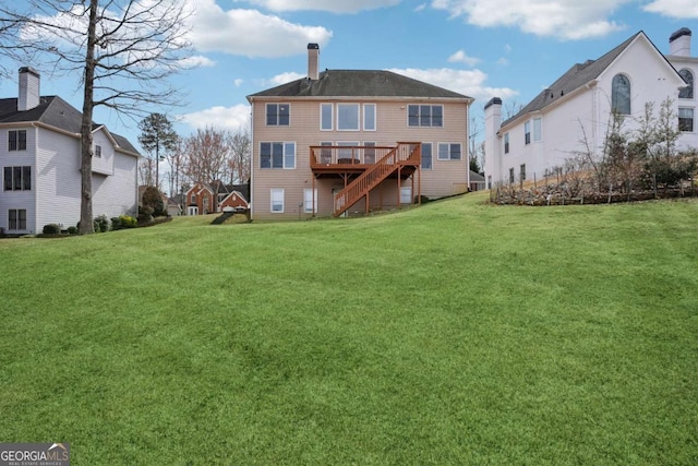 back of house with a wooden deck, stairway, a yard, and a chimney