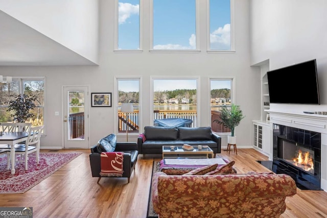 living room with baseboards, a fireplace, and wood finished floors