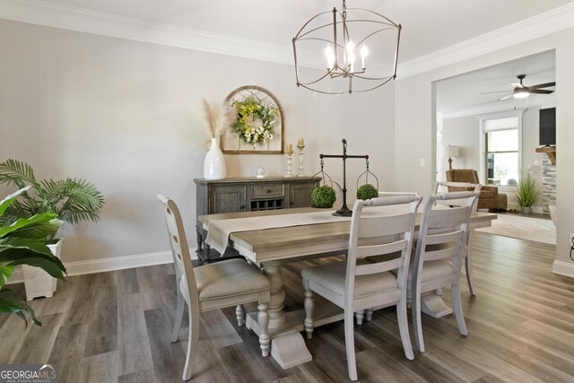 dining area featuring wood finished floors, crown molding, baseboards, and ceiling fan with notable chandelier