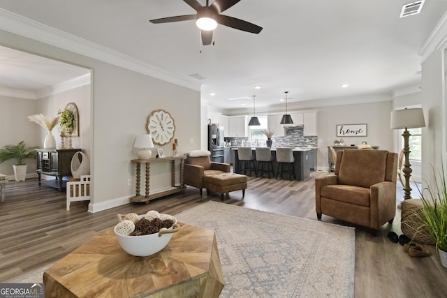 living room featuring recessed lighting, wood finished floors, visible vents, baseboards, and ceiling fan