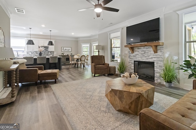 living room featuring recessed lighting, wood finished floors, a ceiling fan, and ornamental molding