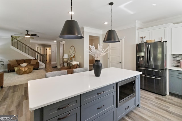 kitchen with stainless steel appliances, light wood-style flooring, backsplash, white cabinetry, and light countertops