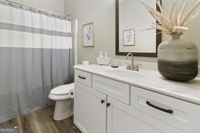 bathroom featuring wood finished floors, vanity, a shower with shower curtain, and toilet