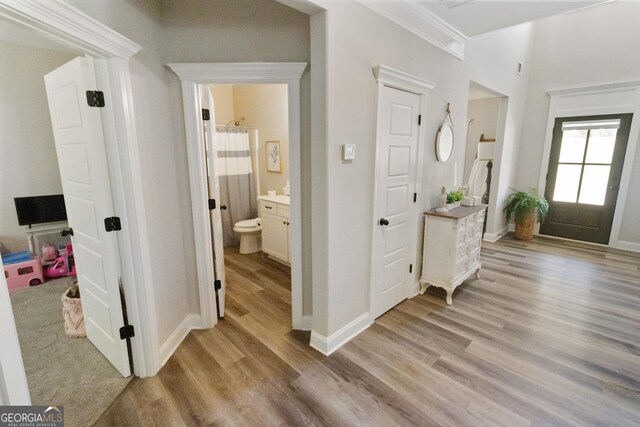 foyer with light wood-style flooring and baseboards