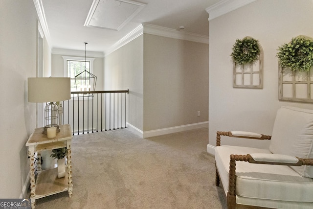 living area with attic access, baseboards, crown molding, and carpet flooring