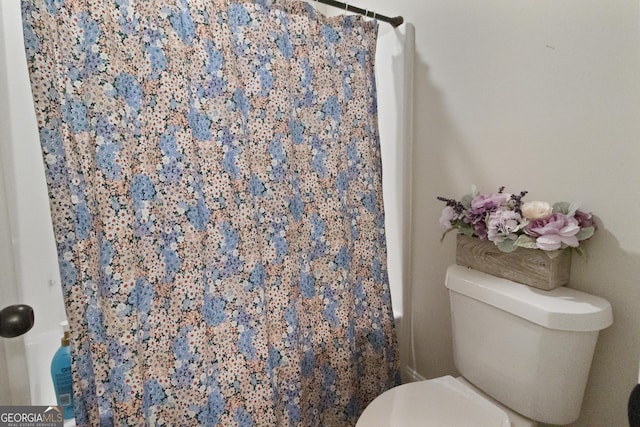 full bathroom with a shower with shower curtain and toilet