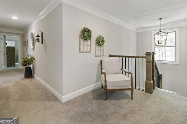 sitting room with baseboards, an upstairs landing, a chandelier, carpet floors, and ornamental molding