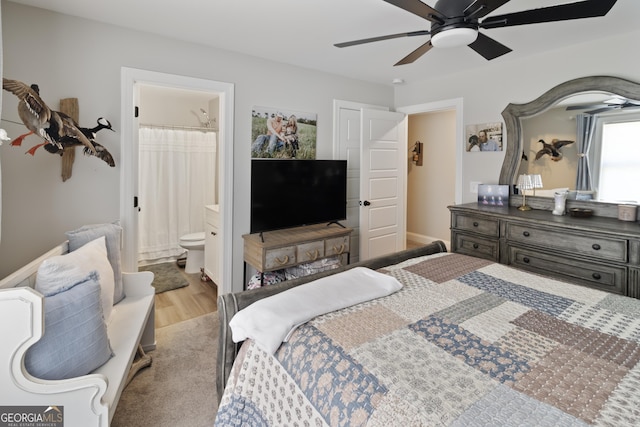 bedroom featuring ensuite bathroom, wood finished floors, and ceiling fan