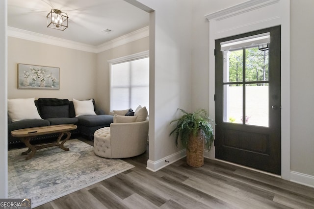 foyer featuring wood finished floors, visible vents, ornamental molding, baseboards, and a notable chandelier