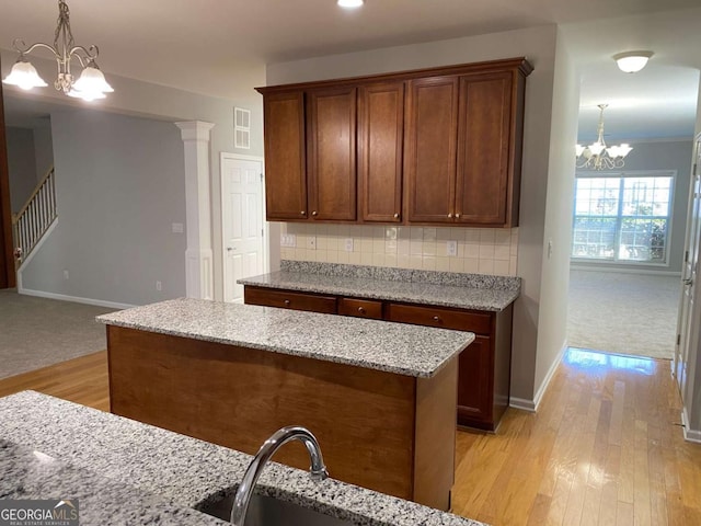 1295 Leisure Lake Dr, Lawrenceville, GA 30044 - kitchen with visible vents, decorative light fixtures, backsplash, light wood-style floors, and an inviting chandelier