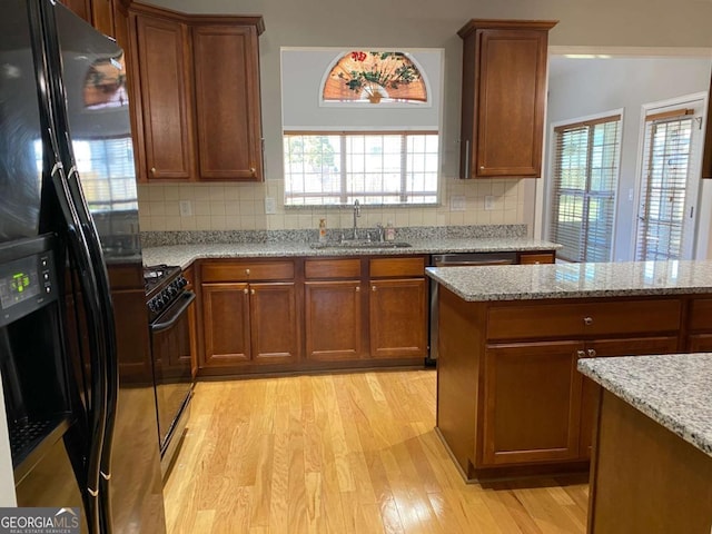 1295 Leisure Lake Dr, Lawrenceville, GA 30044 - kitchen featuring black appliances, brown cabinets, light wood-type flooring, and a sink