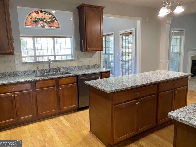 1295 Leisure Lake Dr, Lawrenceville, GA 30044 - kitchen with stainless steel dishwasher, light stone countertops, light wood finished floors, and a sink