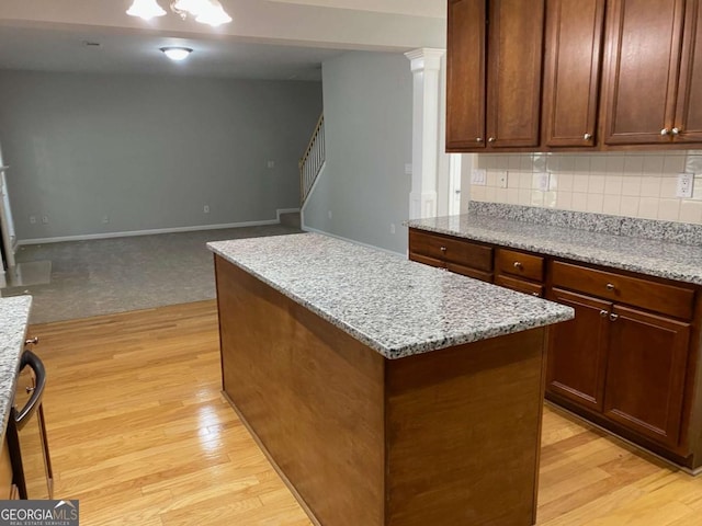 1295 Leisure Lake Dr, Lawrenceville, GA 30044 - kitchen featuring backsplash, a center island, light wood-style flooring, and baseboards