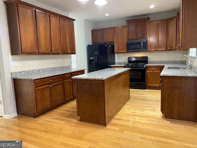 1295 Leisure Lake Dr, Lawrenceville, GA 30044 - kitchen with a sink, a kitchen island, black appliances, and light wood finished floors