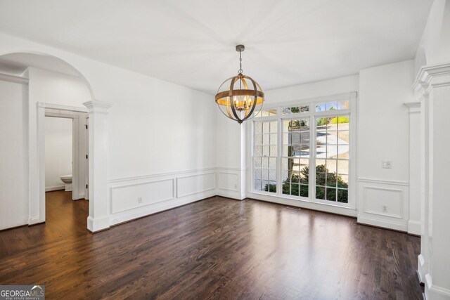 8625 Anchor On Lanier Ct, Gainesville, GA 30506 - unfurnished dining area featuring dark wood-style floors, a chandelier, a decorative wall, wainscoting, and arched walkways