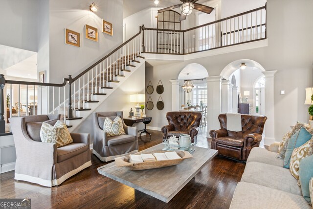 8625 Anchor On Lanier Ct, Gainesville, GA 30506 - living room featuring decorative columns, arched walkways, a high ceiling, wood finished floors, and stairs