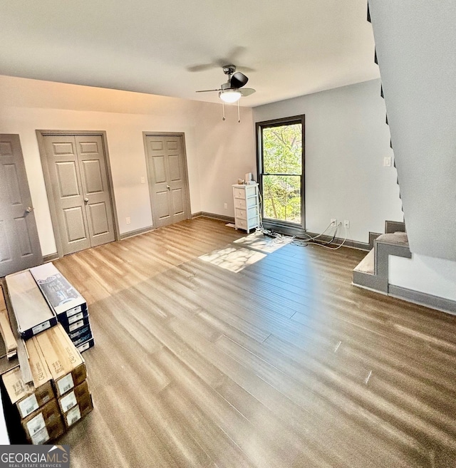 3810 Galloway Dr NE, Roswell, GA 30075 - unfurnished living room featuring ceiling fan, stairs, wood finished floors, and baseboards