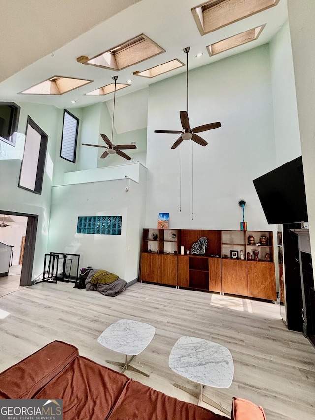 3810 Galloway Dr NE, Roswell, GA 30075 - living area featuring high vaulted ceiling, wood finished floors, ceiling fan, and a skylight