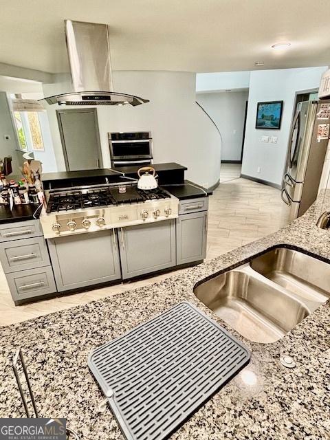 3810 Galloway Dr NE, Roswell, GA 30075 - kitchen featuring island range hood, stainless steel appliances, light stone countertops, a sink, and light wood-style floors