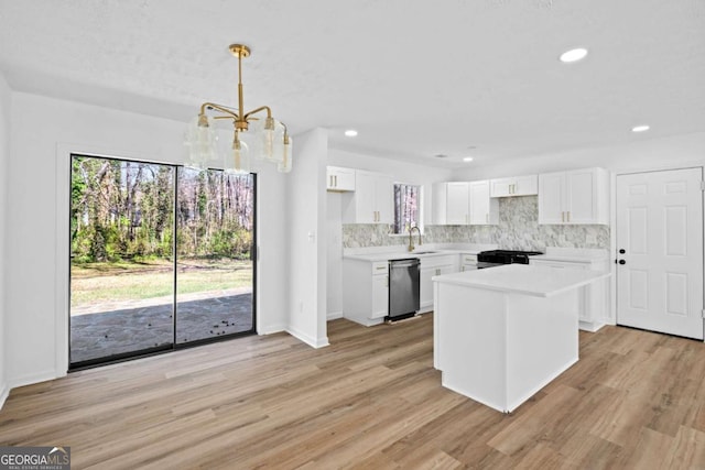 kitchen featuring stainless steel dishwasher, light countertops, tasteful backsplash, and a sink