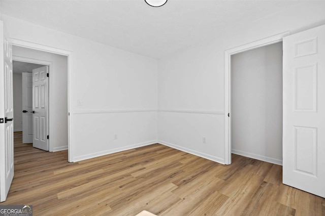 unfurnished bedroom featuring light wood-type flooring and baseboards