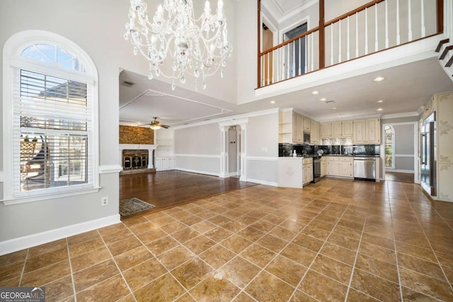 931 New Bedford Dr, Marietta, GA 30068 - unfurnished living room featuring crown molding, baseboards, ceiling fan with notable chandelier, a towering ceiling, and tile patterned floors
