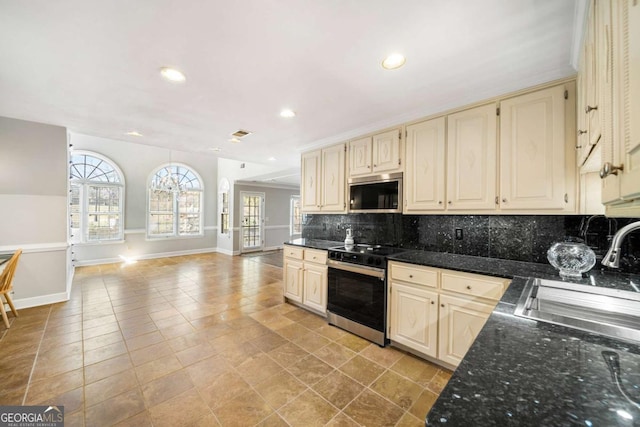 931 New Bedford Dr, Marietta, GA 30068 - kitchen with cream cabinetry, backsplash, and stainless steel appliances