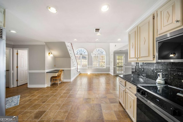 931 New Bedford Dr, Marietta, GA 30068 - kitchen with visible vents, stainless steel microwave, cream cabinets, decorative backsplash, and range