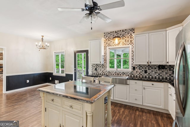 11637 Brown Bridge Rd, Covington, GA 30016 - kitchen with dark wood-type flooring, a chandelier, tasteful backsplash, freestanding refrigerator, and a wainscoted wall