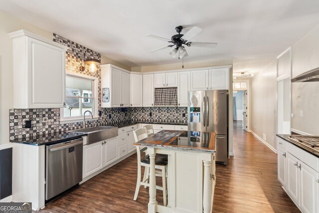 11637 Brown Bridge Rd, Covington, GA 30016 - kitchen featuring appliances with stainless steel finishes, dark countertops, ceiling fan, dark wood-style floors, and white cabinets