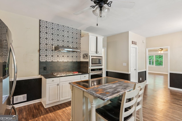 11637 Brown Bridge Rd, Covington, GA 30016 - kitchen featuring appliances with stainless steel finishes, a ceiling fan, wood finished floors, and dark countertops