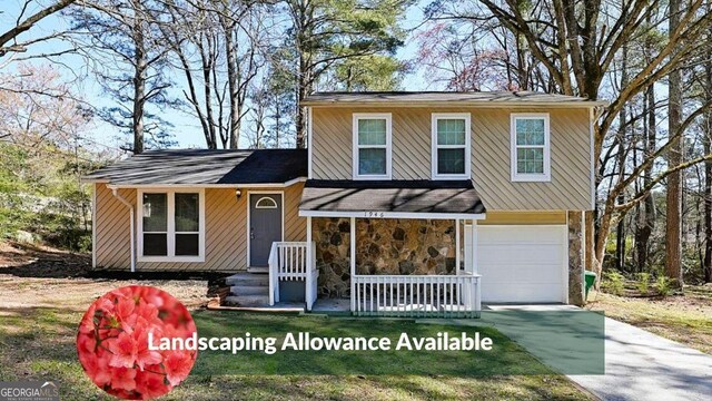 split level home with covered porch, stone siding, a garage, and driveway