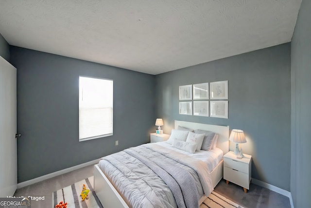 carpeted bedroom featuring baseboards and a textured ceiling