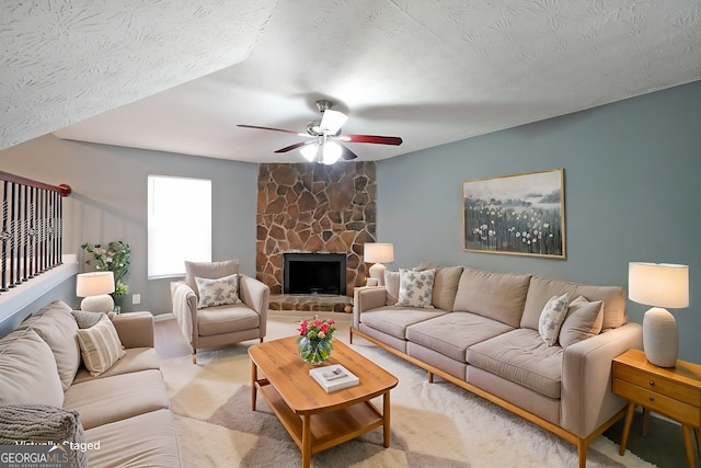 living area featuring a ceiling fan and a fireplace