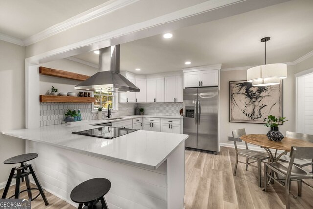 kitchen with a sink, crown molding, island exhaust hood, stainless steel refrigerator with ice dispenser, and open shelves